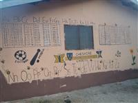 An alphabet and timestable mural on the wall outside the school