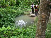 Villagers collect water from a pond