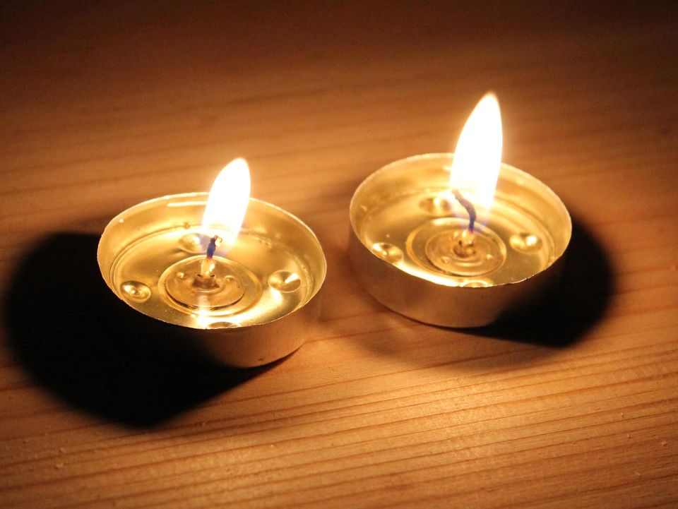 Two candles on a wooden surface