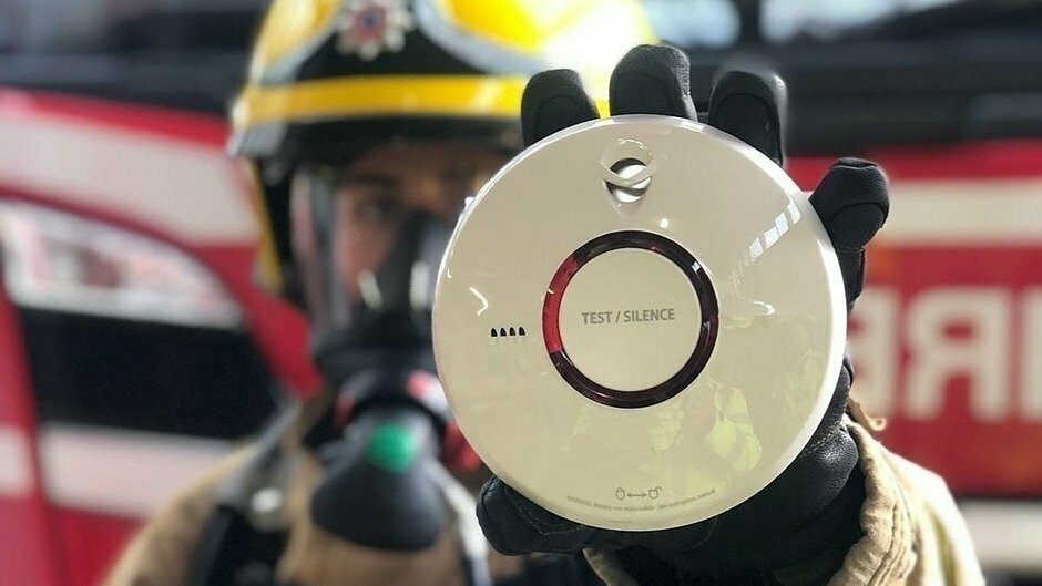 Firefighter holding a smoke alarm